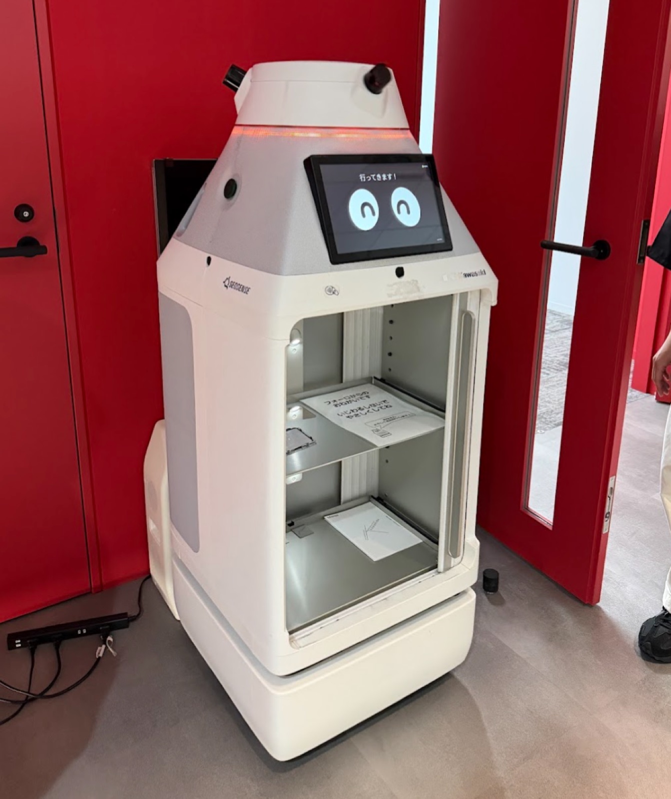 自律走行型デリバリーロボット — 「行ってきます！」 のメッセージ。 施設内外を自走し、 物資の配送・回収を行う
